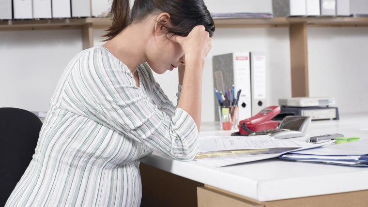 Pregnant woman sitting at desk