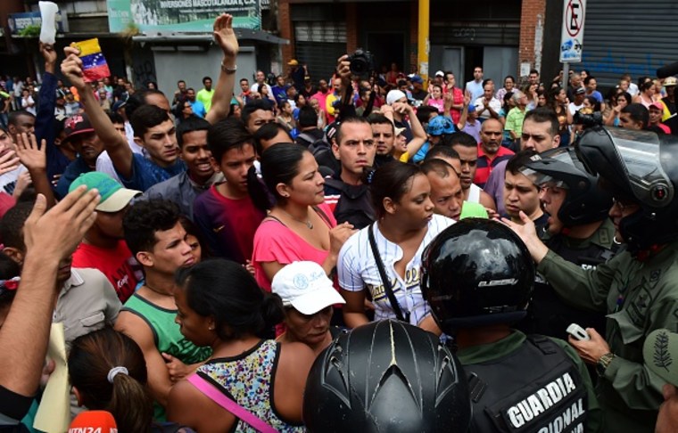 File Photo: People argue with members of the National Guard as they try to line in front of a supermarket in Caracas on June 2, 2016.