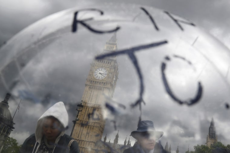 Image: People are seen trough a balloon as she views tributes memory of murdered Labour Party MP Jo Cox, who was shot dead in Birstall, at Parliament Square in London