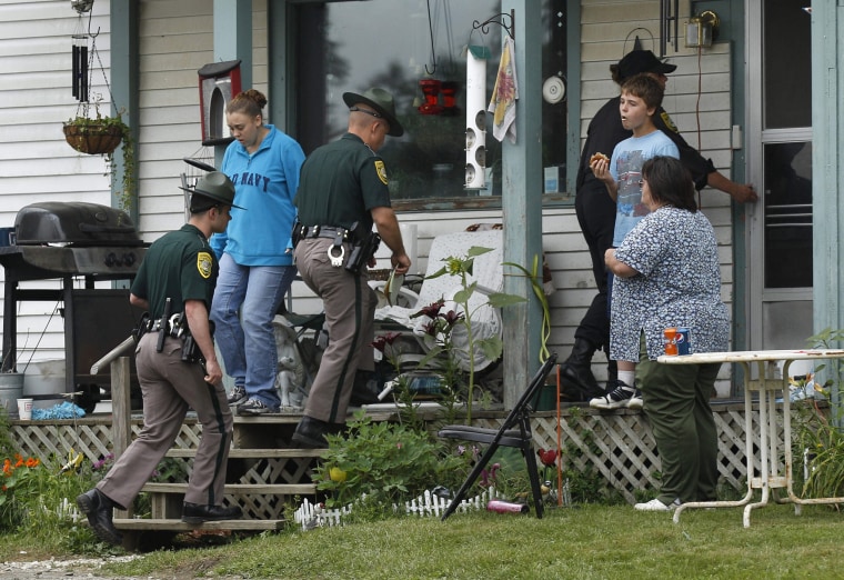 FILE: New Hampshire State Police troopers enter the family home of Celina Cass, in Stewartstown, N.H. Wendell Noyes, 52, of Stewartstown, stepfather of 11-year-old Cass who was found dead in a river in 2011, was arrested Monday on a second-degree murder charge in her killing.