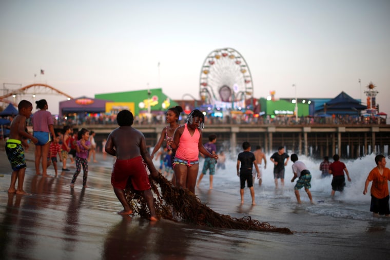 Image: People cool off in the Pacific Ocean during a record-setting heat wave across the U.S. Southwest, on the summer solstice in Santa Monica