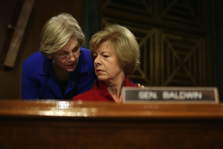 U.S. Sen. Elizabeth Warren (D-MA) (L) talks to Sen. Tammy Baldwin (D-WA) (R) during a hearing before Senate Health, Education, Labor and Pensions Committee February 10, 2015 on Capitol Hill in Washington, DC.