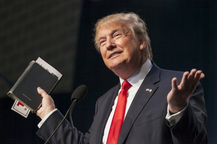 U.S. Republican presidential candidate Donald Trump holds his bible while speaking at the Iowa Faith and Freedom Coalition Forum in Des Moines