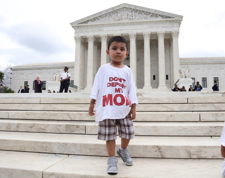 A boy wears a t-shirt reading 'Don't deport my mom'