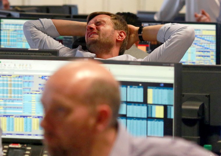 Image: A trader from BGC, a global brokerage company in London's Canary Wharf financial centre reacts during trading