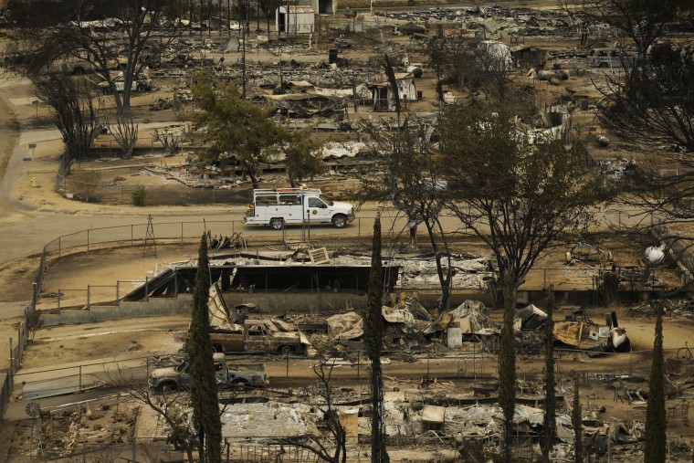 A pickup truck passes by the remains of mobile homes devastated by a wildfire, Saturday, June 25, 2016, in South Lake, Calif.