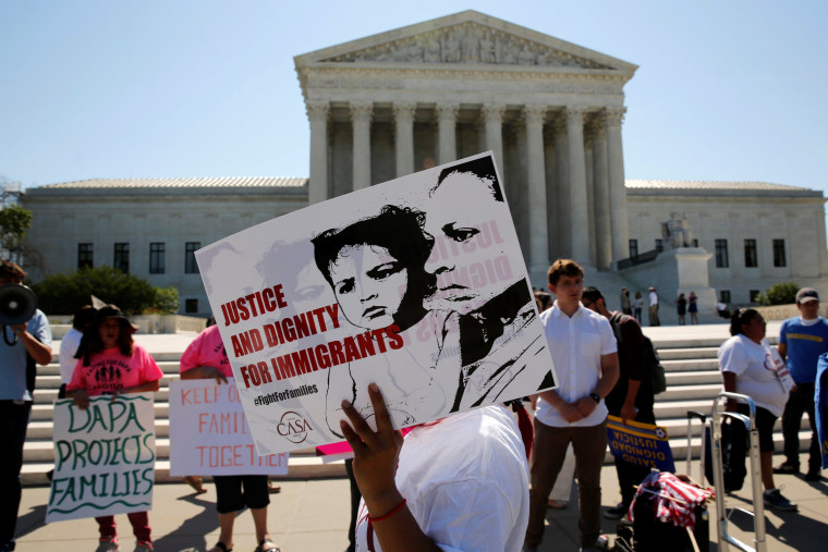 Image: Demonstrators from the immigrant community advocacy group CASA carry signs as they march in the hopes of a ruling in their favor on decisions at the Supreme Court building in Washington