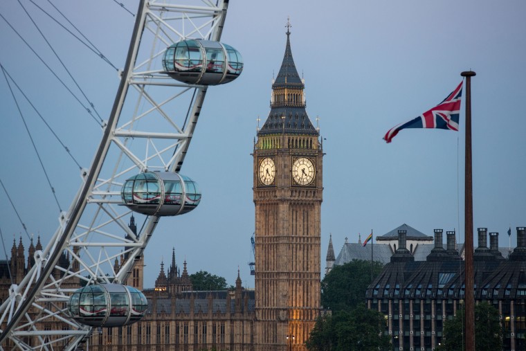 Image: A Union flag flies beside the London Eye in front of the Big Ben and The Houses of Parliament