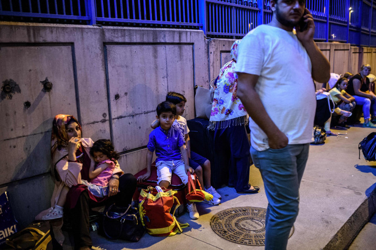 Image: People wait with their luggage outside the Ataturk airport in Istanbul