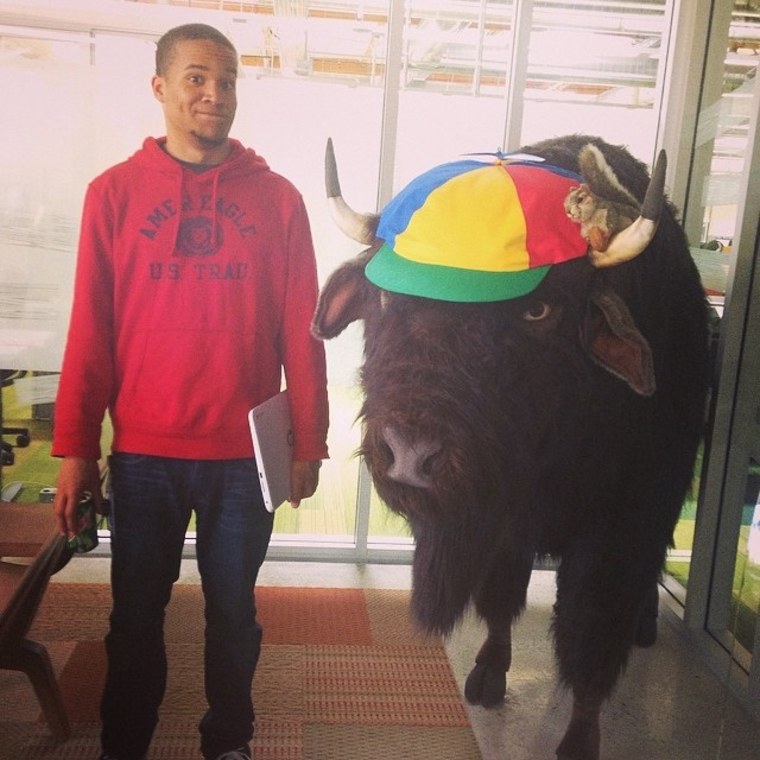 Howard University student Chris Horcutt poses with a bison during his internship after his first year with the GIR program.