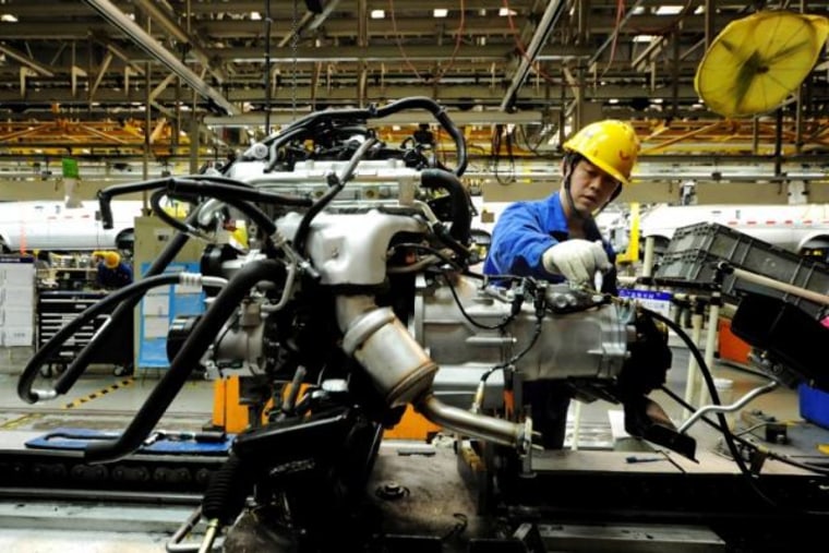 An employee works on an assembly line producing automobiles at a factory in Qingdao
