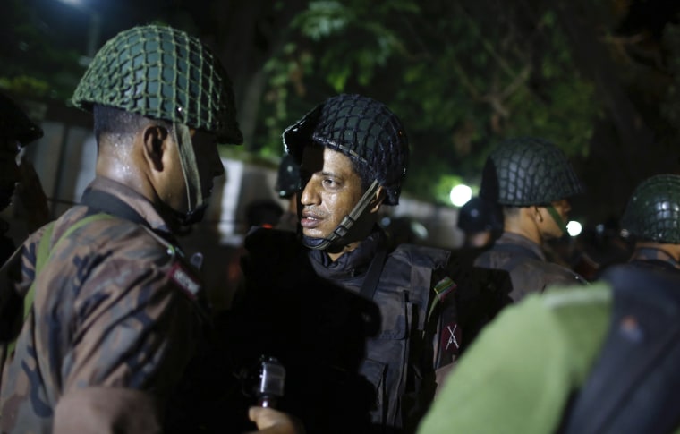 Image: Bangladeshi security personnel stand guard near a restaurant that has reportedly been attacked by unidentified gunmen in Dhaka