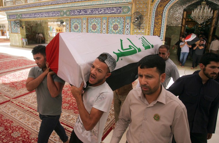Image: Mourners carry coffins of Baghdad bombing victims