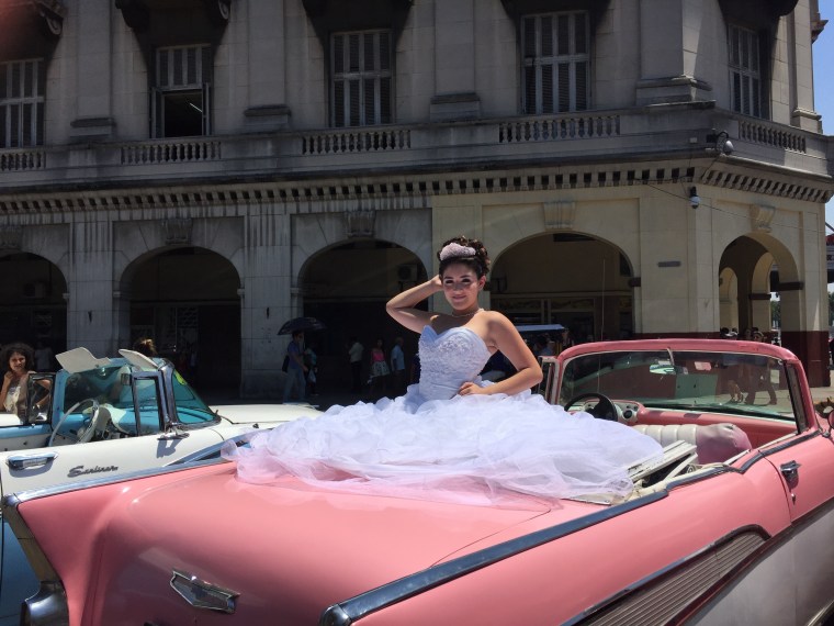Cuban girl poses in a 1957 Chevrolet Bel Air convertible during her "quinceañera" celebration.