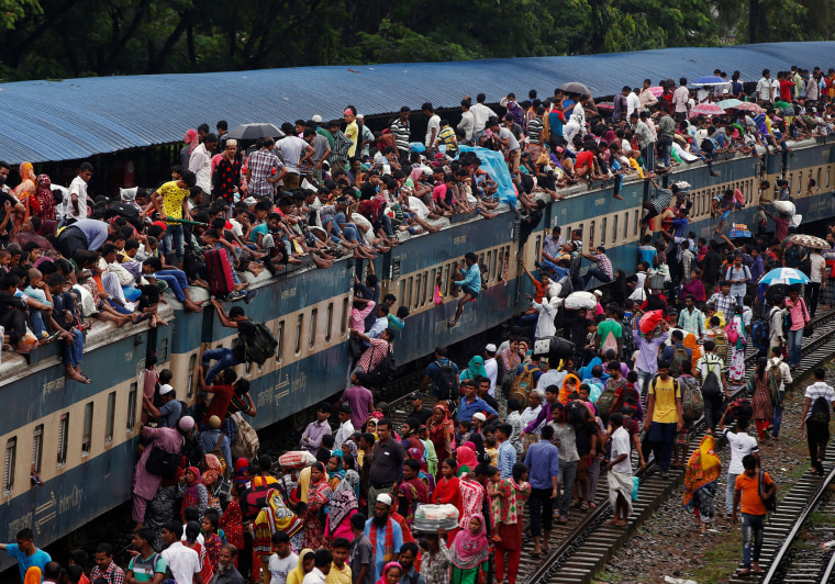 Image: People climb to board an overcrowded passenger train as they travel home to celebrate Eid al-Fitr festival, which marks the end of the Muslim holy fasting month of Ramadan, at a railway station in Dhaka
