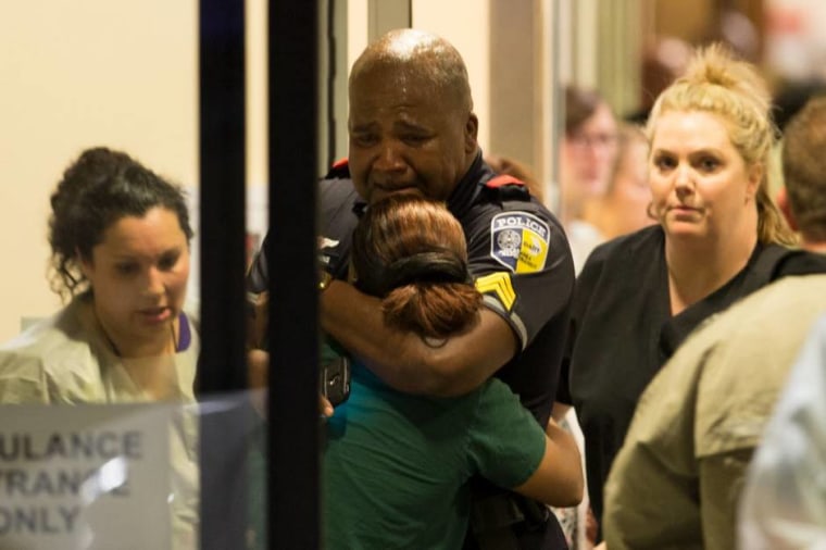 A DART (Dallas Area Rapid Transit) police officer receives comfort at Baylor University Hospital emergency room entrance on July 7, 2016 in Dallas, Texas.