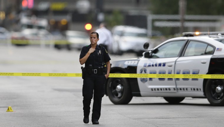 Image: A Dallas Police Officers guards the scene of a shooting
