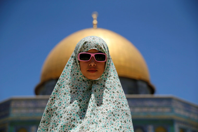 Image: A Palestinian girl prays on the last Friday of the holy fasting month of Ramadan on the compound known to Muslims as Noble Sanctuary and to Jews as Temple Mount in Jerusalem's Old City