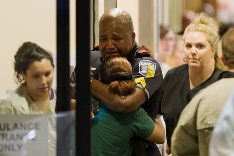 Image: A Dallas Area Rapid Transit police officer receives comfort at an emergency room