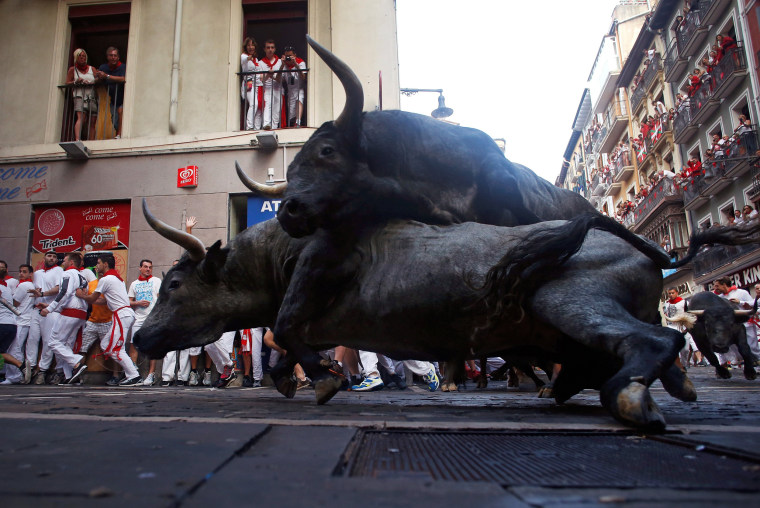 Image: Jose Escolar Gil fighting bulls fall on top of each other at Estafeta corner during the third running of the bulls at the San Fermin festival in Pamplona