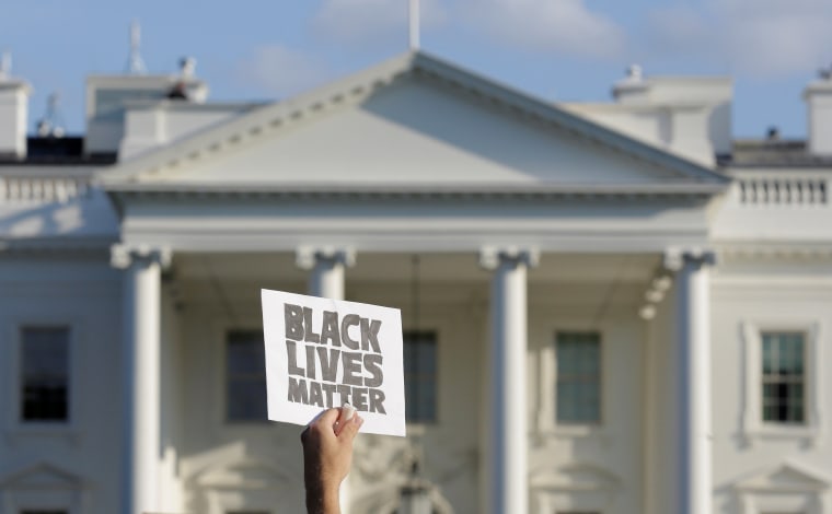 Image: A demonstrator with Black Lives Matter holds up a sign during a protest in front of the White House in Washington.
