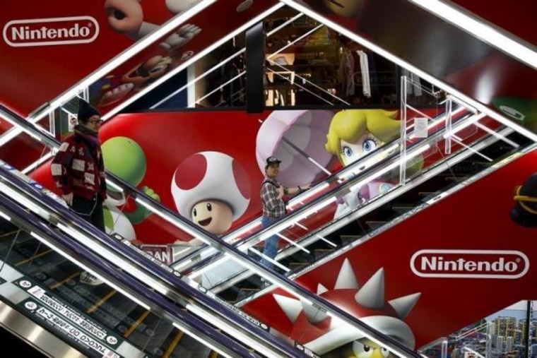 People ride escalators past an advertisement of the Nintendo Co videogame maker at an electronic retailer in Tokyo