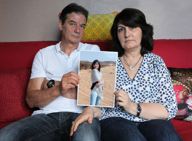 Jean-Luc and Catherine Vannier pose for a photo holding a picture of their daughter C?cile Vannier