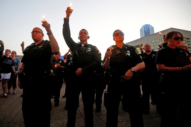 Image: Dallas police officers take part in a candlelight vigil at Dallas City Hall