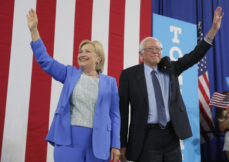 Image: Democratic U.S. presidential candidates Clinton and Sanders stand together during campaign rally in Portsmouth, New Hampshire