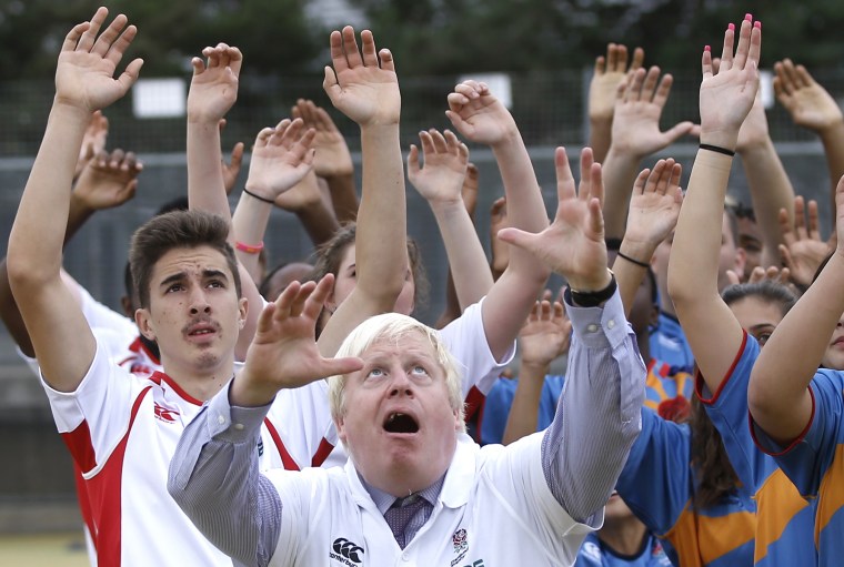 Image: London Mayor Boris Johnson jumps for the ball during a rugby coaching session at Haverstock School in London