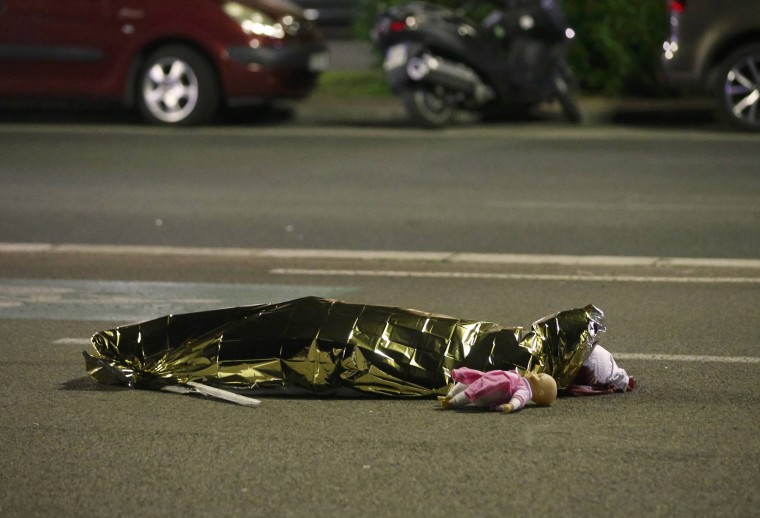 Image: A body is seen on the ground after at least 30 people were killed in the southern French town of Nice when a truck ran into a crowd celebrating the Bastille Day national holiday