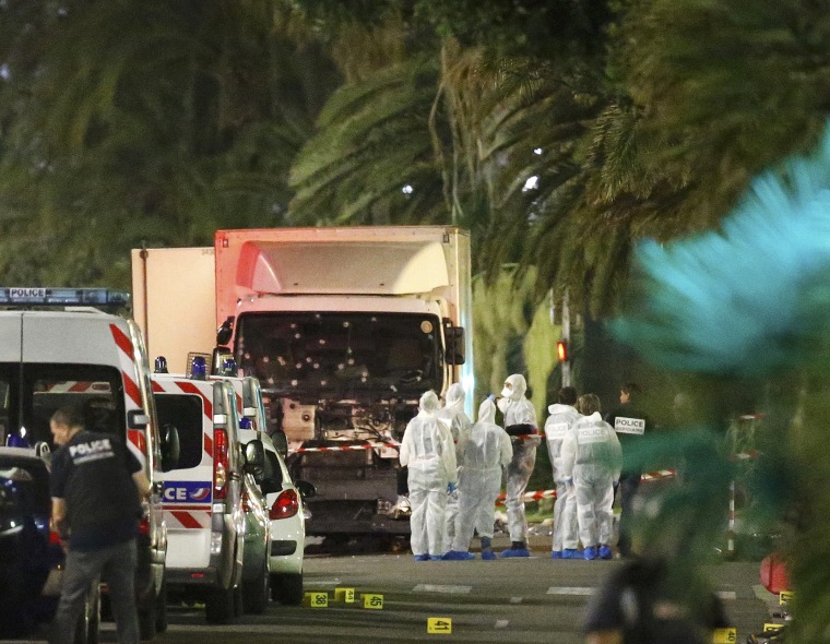 Image: French police forces and forensic officers stand next to a truck that ran into a crowd celebrating the Bastille Day national holiday on the Promenade des Anglais killing at least 60 people in Nice