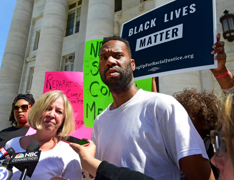 Lawyer Patricia Kane of New Haven, second from left, with her client Corey Menafee, a former employee at Yale's Calhoun College who was arraigned for breaking a window pane depicting black slaves picking cotton at Calhoun College, right, talk with the press as they leave New Haven Superior Court on Chapel Street in New Haven on July 12, 2016.