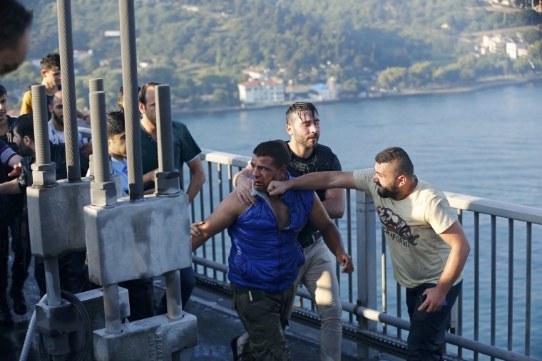 Image: A civilian beats a soldier after troops involved in the coup surrendered on the Bosphorus Bridge in Istanbul