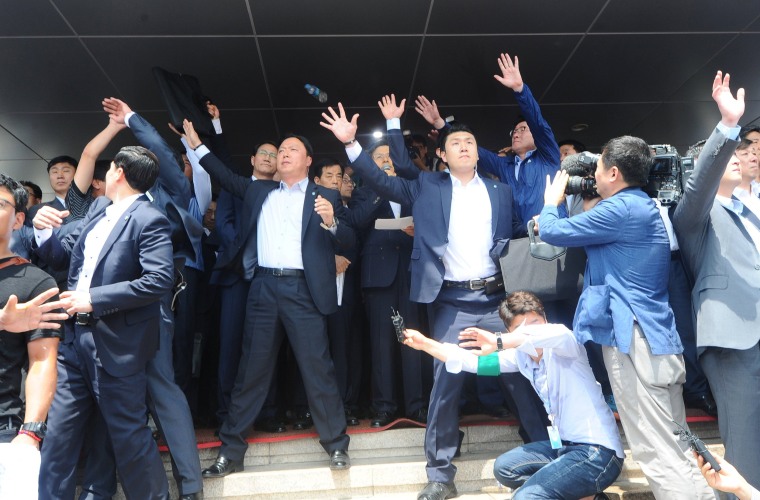 Image: Security personnels try to protect South Korean Prime Minister Hwang Kyo-ahn from bottle and eggs thrown by angry residents in Seongju where a U.S. THAAD anti-missile defense unit will be deployed
