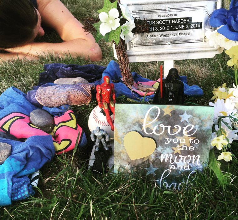 Ashley Grimm lying on the grave of her son Titus