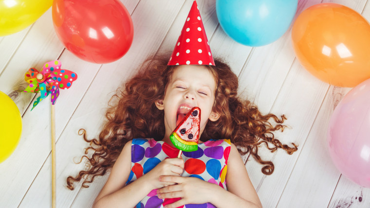 little girl licking a lollipop.