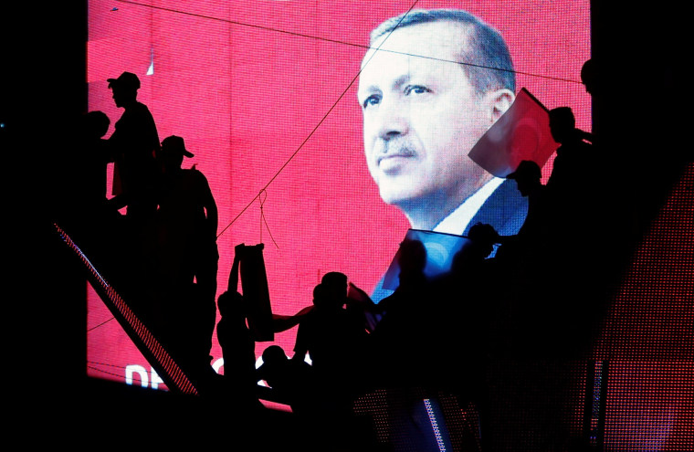 Image: Turkish Supporters are silhouetted against a screan showing President Tayyip Erdogan during a pro-government demonstration in Ankara