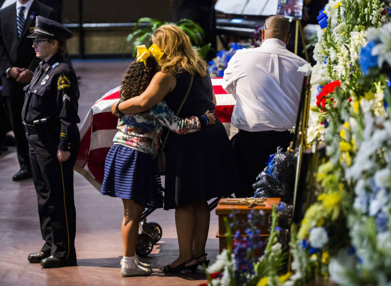 Image: Family members share a moment during a funeral service during a funeral service for police officer Zamarripa, a former U.S. Navy veteran, who was among five police officers shot dead the previous week, in Fort Worth