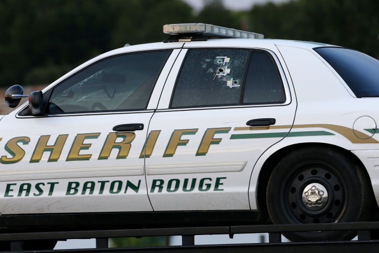 Image: An East Baton Rouge Sheriff vehicle is seen with bullet holes in its windows near the scene where police officers were shot, in Baton Rouge