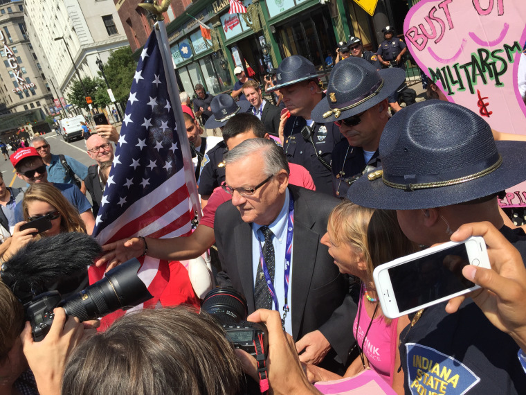 Sheriff Joe Arpaio of Maricopa County, Ariz., walks past a group of protester from Code Pink on Tuesday, July 19, in Cleveland, during the second day of the Republican convention as he enters the Quicken Loans Arena.