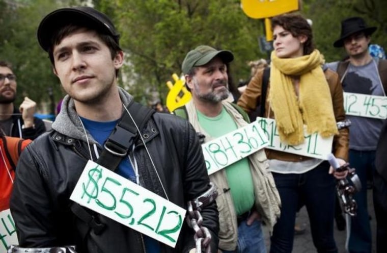 Occupy Wall Street demonstrators participating in a street-theater production wear signs around their neck representing their student debt during a protest against the rising national student debt in Union Square, in New York