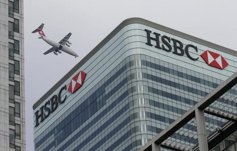 A Swiss International aircraft flies past the HSBC headquarters building in the Canary Wharf financial district in east London