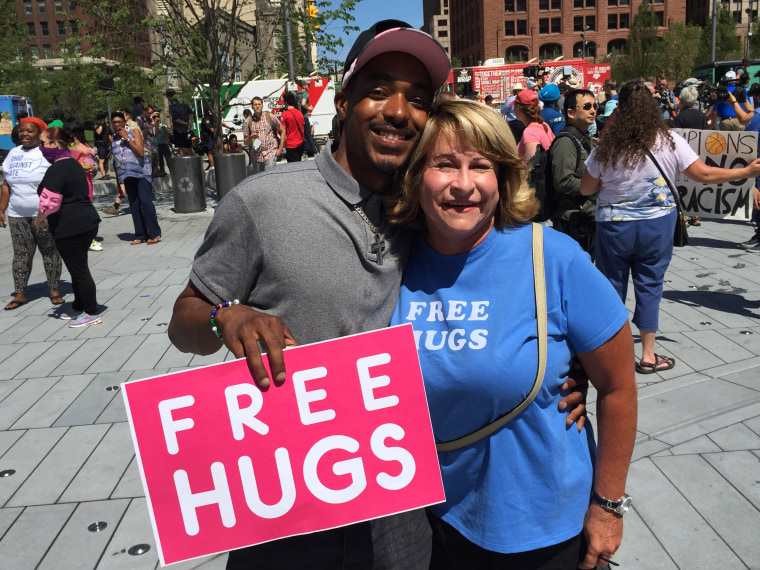 Xavier Willis, 29, of Cleveland and Kim Snyder, 57, of Parma, Ohio have been offering free hugs. Willis says he's a spiritual therapist and Trump fan. Snyder, a minister, also supports Trump but says she is out in the square to "support police."