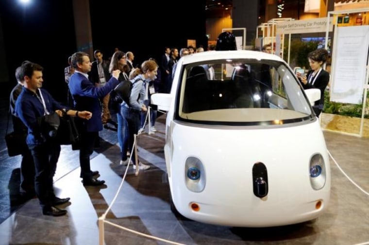 Visitors look at a self-driving car by Google displayed at the Viva Technology event in Paris