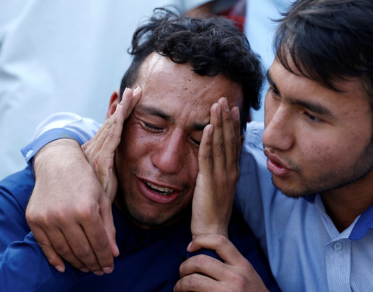 Image: An Afghan man weeps outside a hospital after a suicide attack in Kabul, Afghanistan