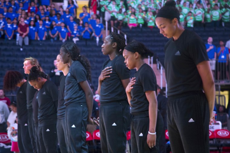 Members of the New York Liberty basketball team stand during the playing of the Star Spangled Banner prior to a game against the Atlanta Dream, Wednesday, July 13, 2016 in New York. In the midst of "Camp Day"?? at the New York Liberty's mid-morning game Wednesday, Liberty players stood in solidarity as they donned all-black warmups in support of the Black Lives Matter movement.