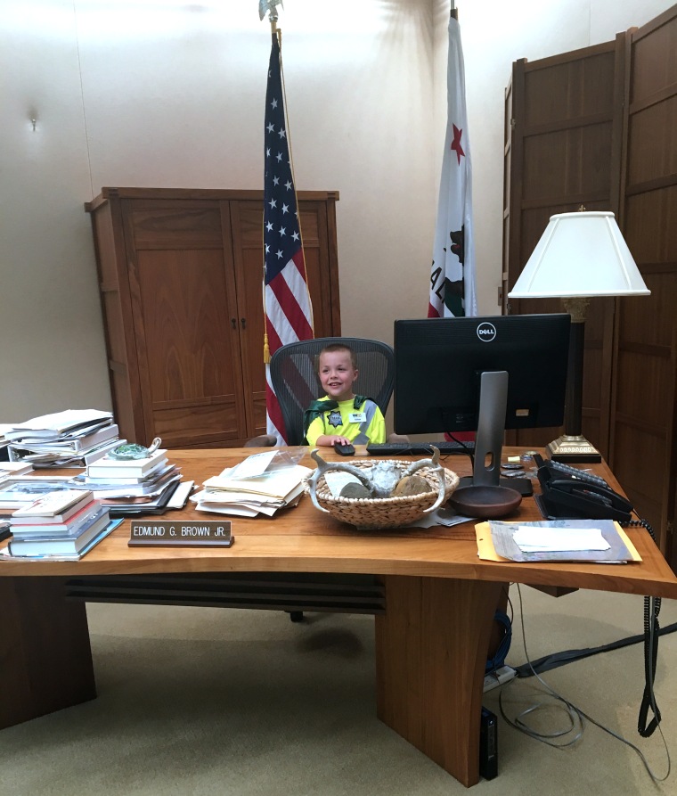 Ethan sits at Governor Jerry Brown's desk after receiving a private tour of the Governor's office'