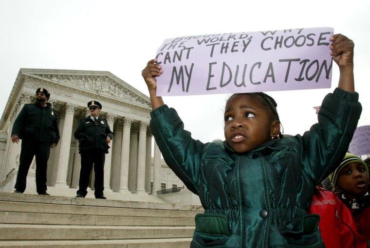 Brianna Slater, 5-years-old, of Richmond, Virginia holds up a sign which states support of school vouchers in front of the U.S. Supreme Court February 20, 2002 in Washington, DC.