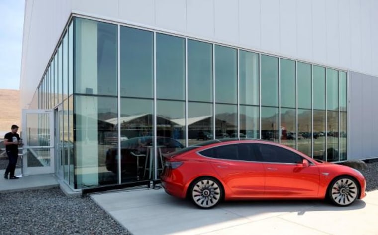 A prototype of the Tesla Model 3 is on display in front of the factory during a media tour of the Tesla Gigafactory which will produce batteries for the electric carmaker in Sparks